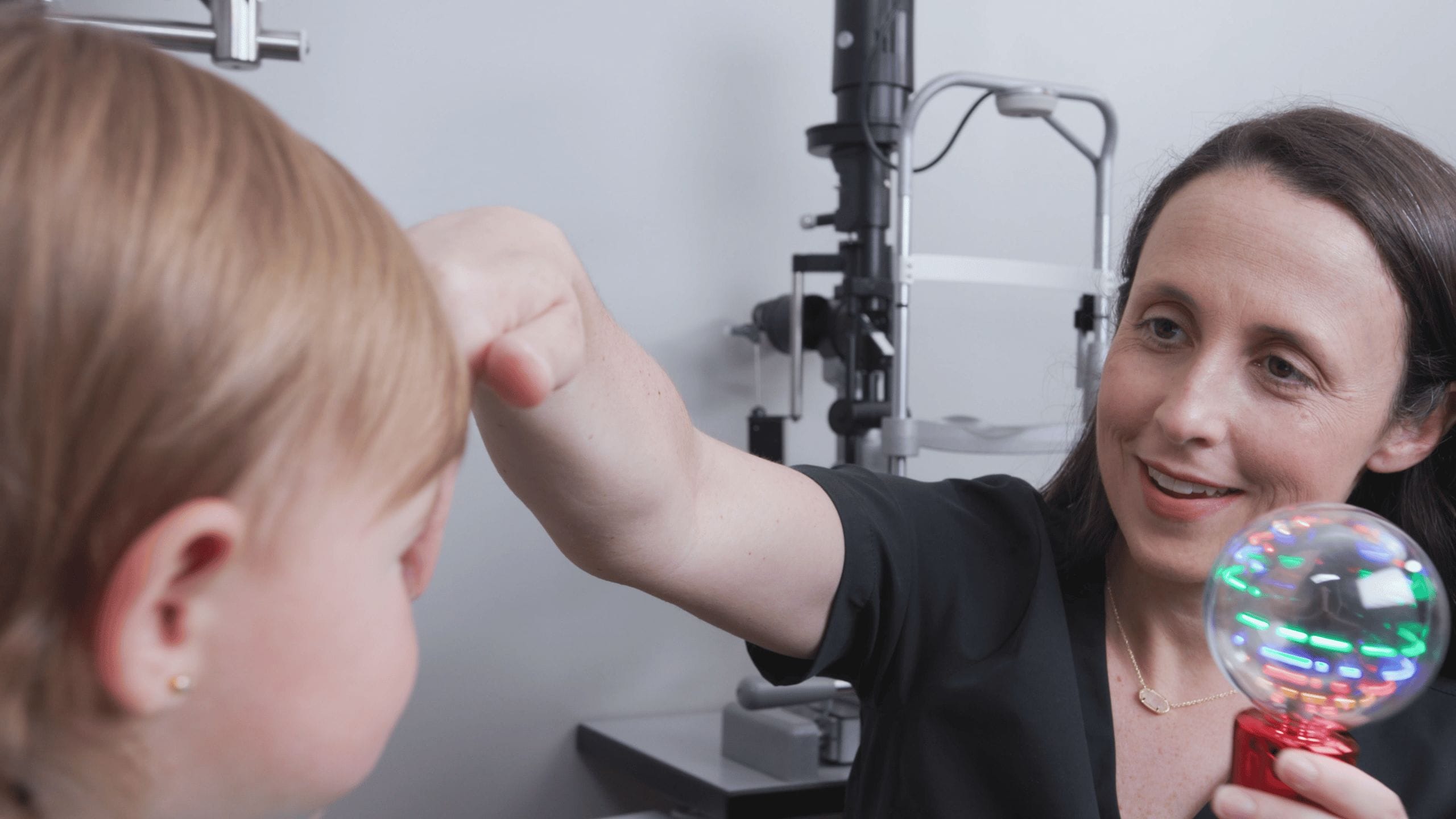 Melissa Shipley performing a child eye exam with a light-up toy