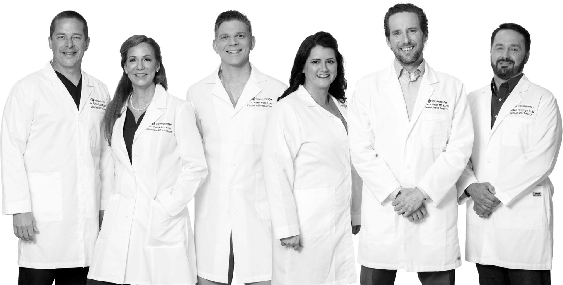 Some of Wilmington Eye's surgeons standing in a line smiling in white coats
